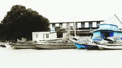 Boats moored on shore against clear sky