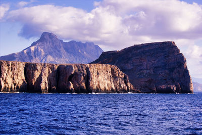 Scenic view of sea and mountains against sky