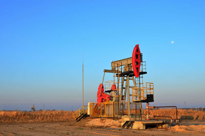 Construction site on field against clear blue sky