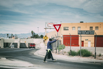 Man on road against sky in city