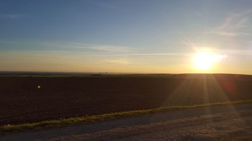 Scenic view of field against sky at sunset