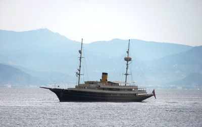 Sailboat on sea against mountain range