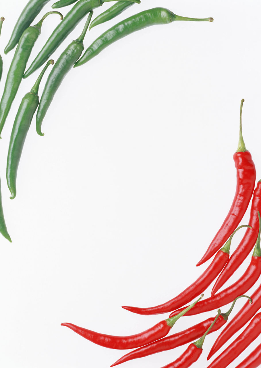 CLOSE-UP OF RED CHILI PEPPER AGAINST COLORED BACKGROUND