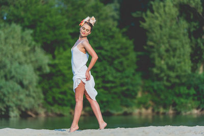 Portrait of young woman standing against plants