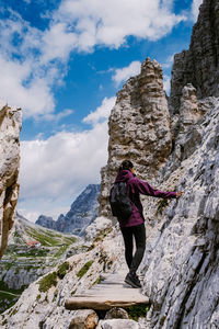 Rear view of man on rock against sky