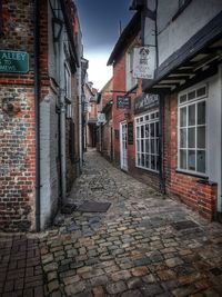 Empty alley amidst buildings in city