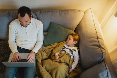 Friends sitting on sofa at home