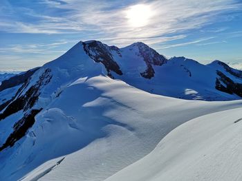 Scenic view of snow covered mountains against sky