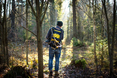 Man standing on tree trunk in forest