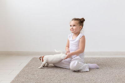 Cute boy looking away while sitting on wall