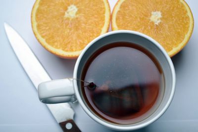 High angle view of tea with halved orange on table