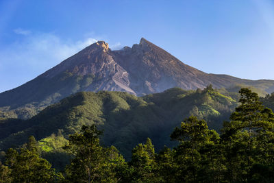 Scenic view of mountains against blue sky