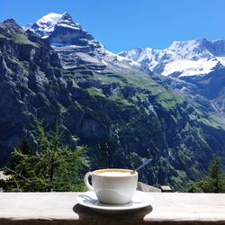 Coffee cup against mountains in background