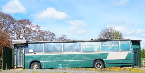 Car parked by road against blue sky