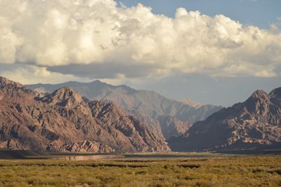 Scenic view of mountains against cloudy sky