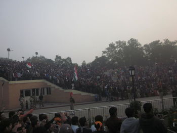 Crowd on road against sky