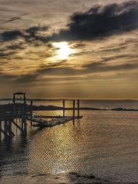 Pier over sea against sky during sunset