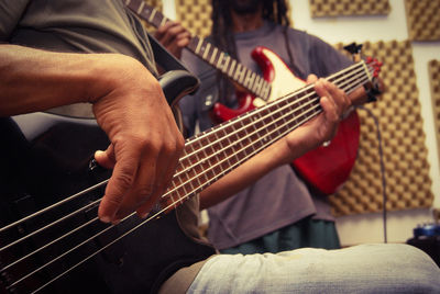 Midsection of man playing guitar