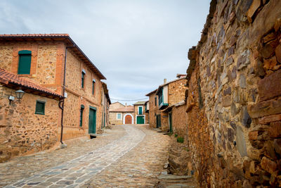 Narrow alley amidst buildings against sky