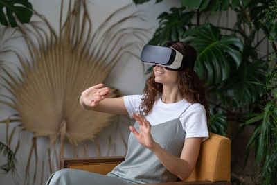 Happy woman in virtual reality goggles headset touching vr screen use modern augmented technology