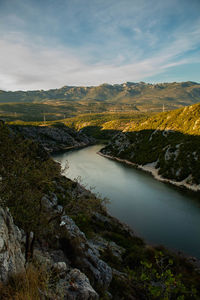 Scenic view of lake by mountains against sky