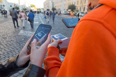 Low section of people using smart phone on street