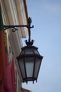 Low angle view of bird perching on building against sky