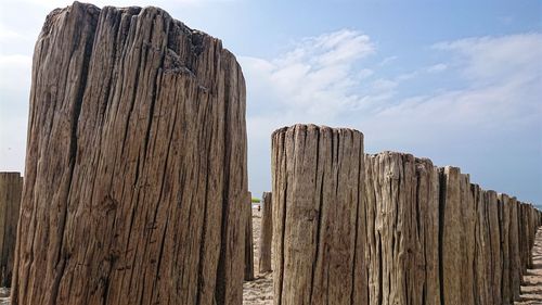 Low angle view of wooden post against sky