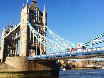 Tower bridge over thames river against clear blue sky