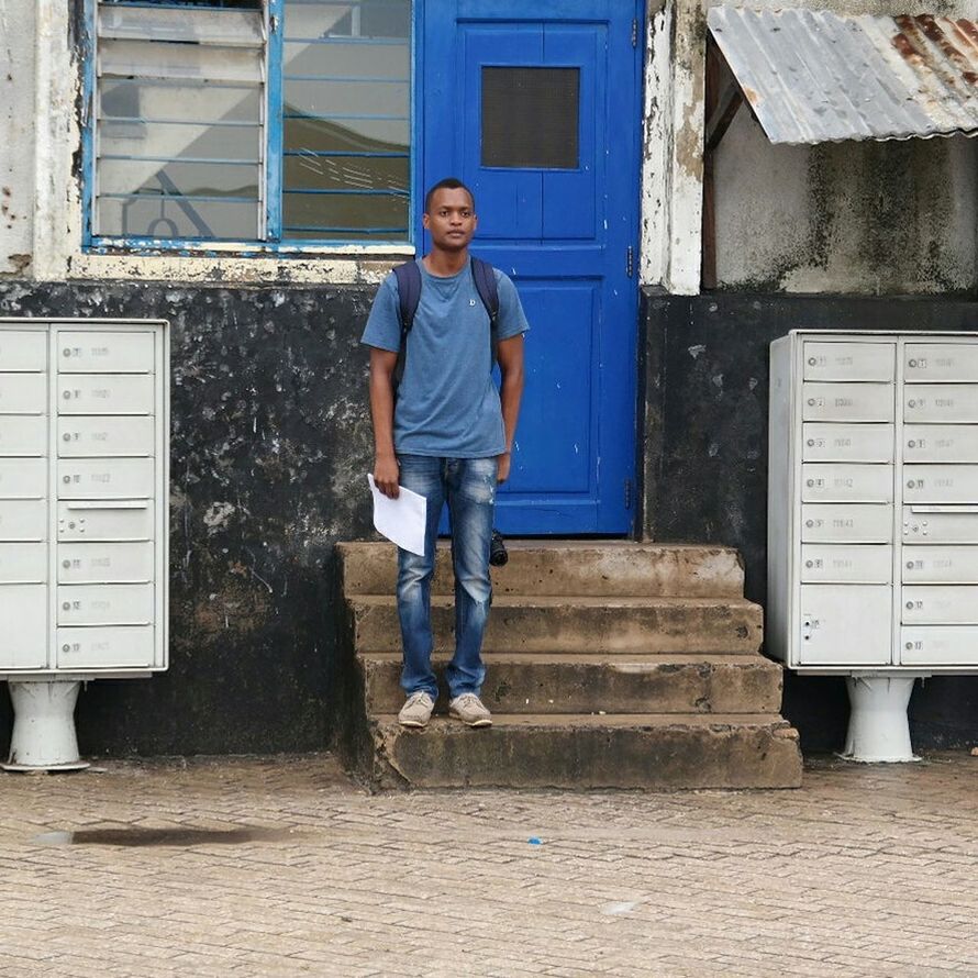 architecture, built structure, full length, building exterior, casual clothing, person, lifestyles, young adult, standing, leisure activity, front view, wall - building feature, steps, portrait, looking at camera, young men, building, brick wall