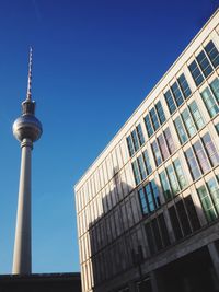 Low angle view of communications tower in city