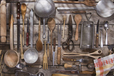 Various kitchen utensils hanging on wood