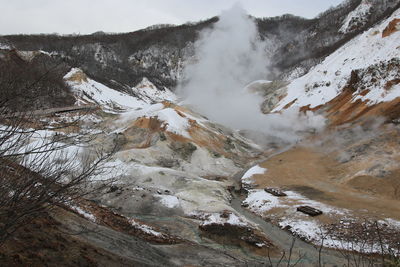 Smoke emitting from volcanic geyser against sky