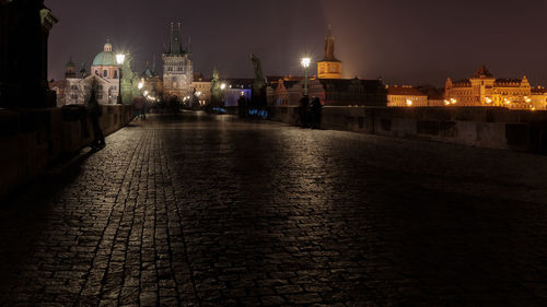 View of illuminated street amidst buildings at night