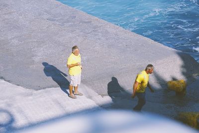 High angle view of children standing in sea