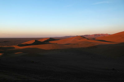 Scenic view of desert against sky during sunset