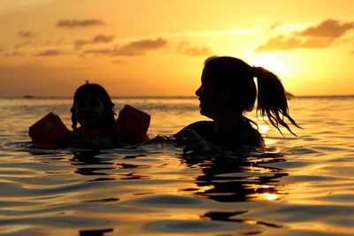 Close-up of mother and daughter swimming in sea