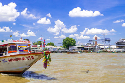 Boats in sea against cloudy sky