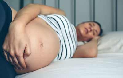 Pregnant woman lying on bed