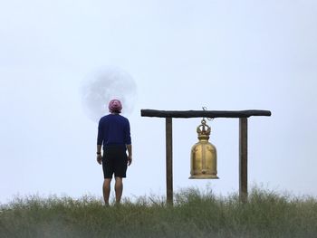 Rear view of man standing against sky