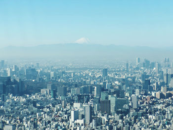 Aerial view of buildings in city against sky