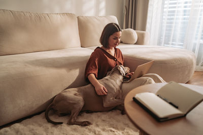 Portrait of woman using mobile phone while lying on bed at home