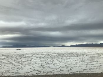 Scenic view of land against cloudy sky