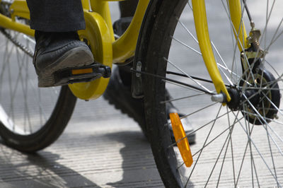 Low section of person with bicycle on yellow background