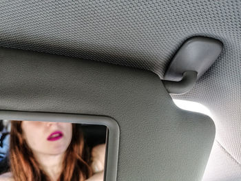 Painted lips of woman in rear-view mirror