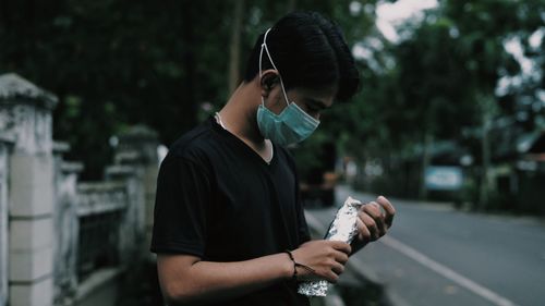 Man holding umbrella standing on road