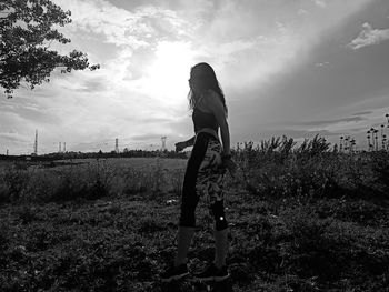 Woman standing on field against sky