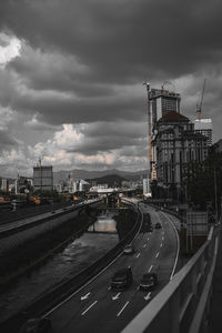 Vehicles on road against sky in city