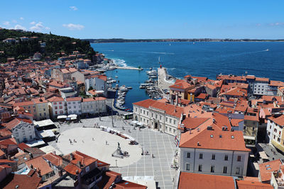 High angle view of townscape by sea against sky