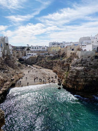 View of buildings by sea against sky